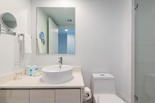 a bathroom with a sink and a toilet and a mirror at Modern Studio rental at Beachwalk Resort Hollywood 18th floor in Hollywood