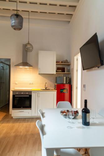 a kitchen with a white table and a red refrigerator at Apartamentos El Alcazar de Jerez in Jerez de la Frontera