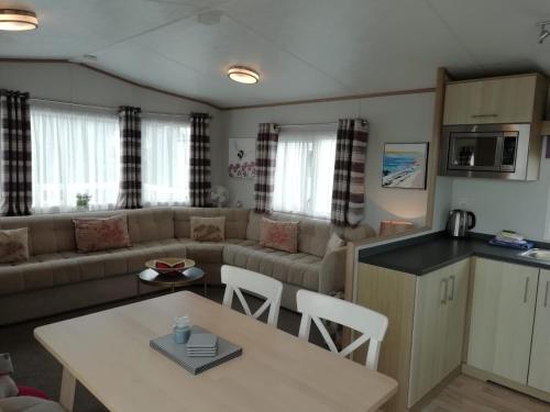 a living room with a couch and a table at The Trailer By The Sea in Millom