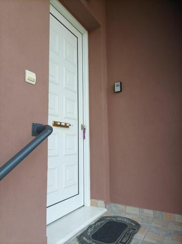 a white door in a room with a door mat at The Other Side of Meteora with lush garden, BBQ & pavillion in Kalabaka