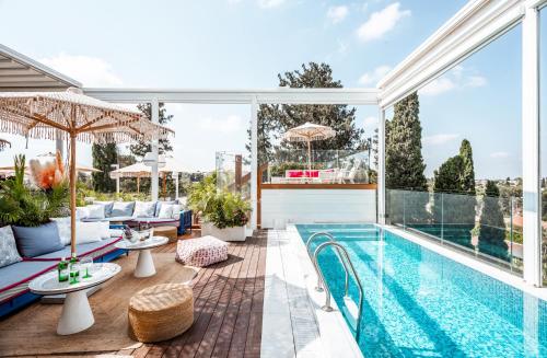 an indoor swimming pool with a patio furniture and a swimming poolvisor at Lear Sense Hotel in Gedera