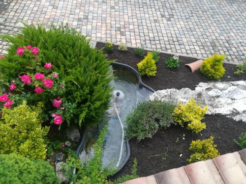 a garden with pink flowers and a sink at Complesso turistico Aurora - Appartamenti in Poggio Picenze