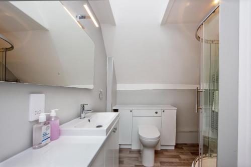 a white bathroom with a toilet and a sink at Island View in Oban