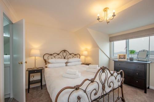 a bedroom with a bed with two chairs and a window at Island View in Oban