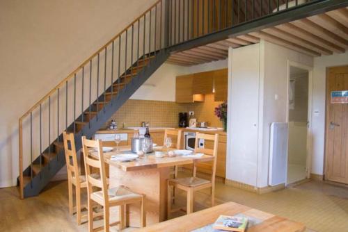a kitchen with a dining table and a staircase at Mas de la Barque in Gourdouze