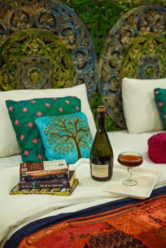 - une bouteille de vin et un verre sur le lit dans l'établissement Bhim Kothi, à Jaisalmer