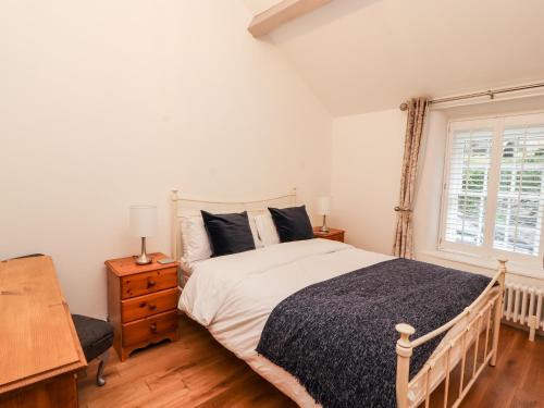 a bedroom with a large bed and a window at Glan Y Ddol in Trefriw