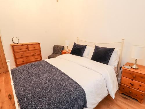 a bedroom with a large white bed and a dresser at Glan Y Ddol in Trefriw