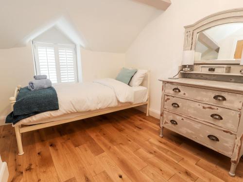 a bedroom with a dresser and a mirror at Glan Y Ddol in Trefriw