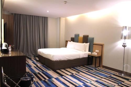 a hotel room with a bed and a table and a lamp at Ewaa Express Hotel - Al Olaya in Riyadh