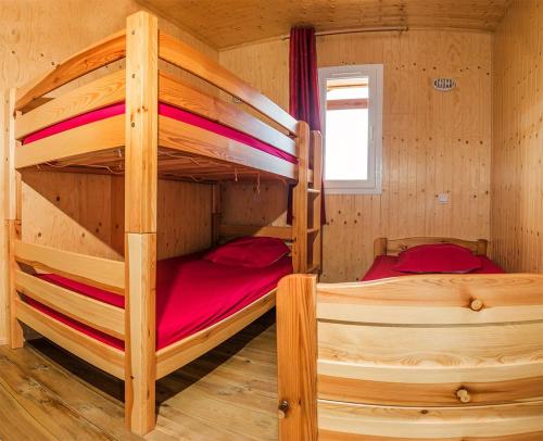 two bunk beds in a wooden cabin with a window at les balcons du grand puy in Seyne