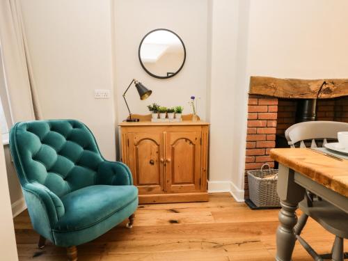 sala de estar con silla azul y espejo en Snowdrop Cottage, en Windermere