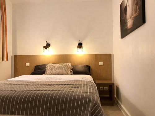 a bedroom with a bed with two lights above it at STEPS TO THE BEACH apart in CANNES with Parking in Cannes