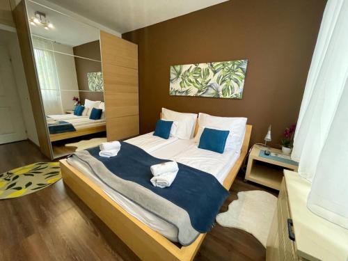 sypialnia z dużym łóżkiem z niebieskimi poduszkami w obiekcie Nagyerdei Rózsahegy 1 Apartman Greatforest Rosehill 1 Apartment w Debreczynie