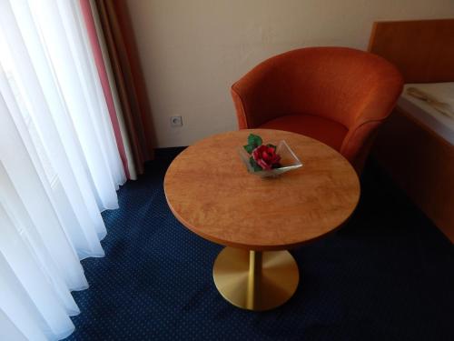 a table and a chair with a bowl of fruit on it at BSW Schwarzwaldhotel Baiersbronn in Baiersbronn