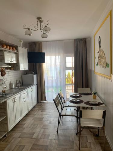 a kitchen with a table and a dining room at Flower Breeze in Chebanka