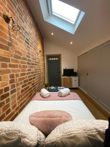 a bedroom with a brick wall and a bed at New Converted Barn in Hereford