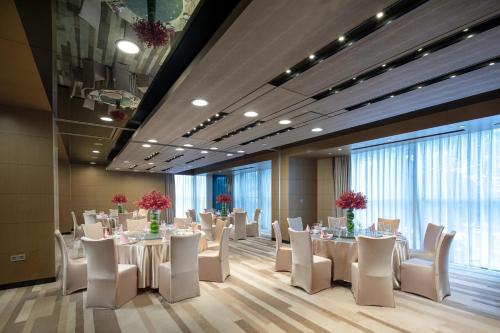a conference room with tables and white chairs at Crowne Plaza Guangzhou Huadu by IHG - Free Shuttle bus between hotel to Exhibition Center During Canton Fair in Guangzhou