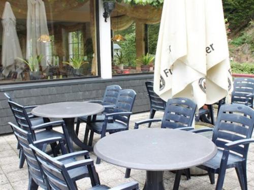 a group of tables and chairs with an umbrella at Hotel Winneburg in Cochem