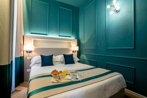 a bedroom with a large bed with blue walls at Hotel Monte Rosa in Chiavari
