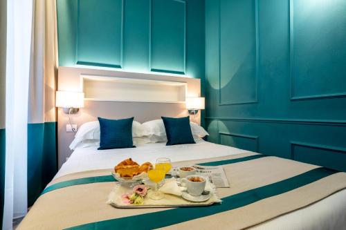 a hotel room with a bed with a tray of food on it at Hotel Monte Rosa in Chiavari