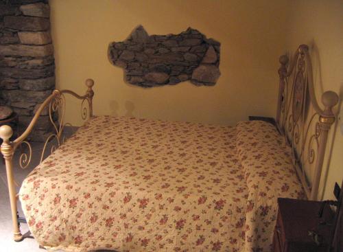 a bed in a bedroom with a stone wall at Les Chevreuils in Arvier