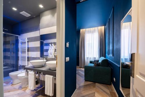 a blue bathroom with two sinks and a toilet at Hotel Monte Rosa in Chiavari