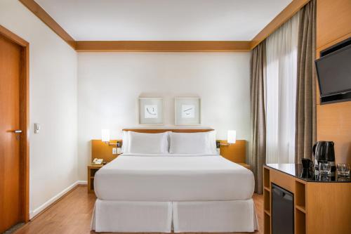 a hotel room with a bed and a television at São Paulo Tatuape, Affiliated by Meliá in Sao Paulo