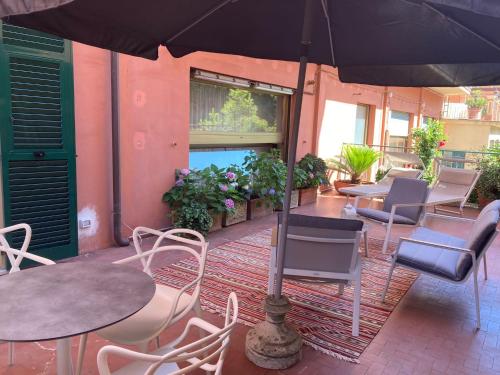 a patio with tables and chairs and an umbrella at Hotel Monte Rosa in Chiavari