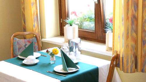 a table with a blue and white table cloth and a window at Hotel Garni Kluth in Bonn