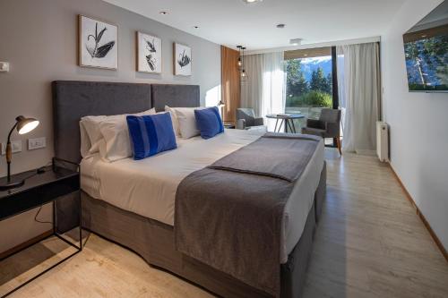 1 dormitorio con 1 cama grande con almohadas azules en Hotel Alto Traful en Villa Traful