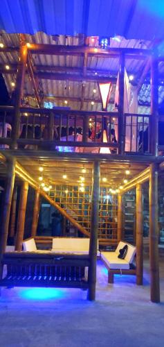 a large wooden building with a bench and stairs at Soga Hostal in Santa Marianita
