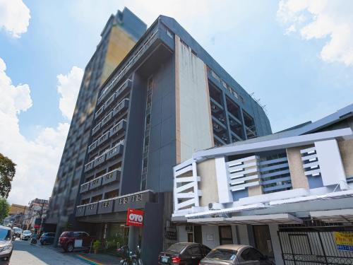 ein hohes Gebäude mit davor geparkt in der Unterkunft OYO 115 Northridge Mansions in Manila