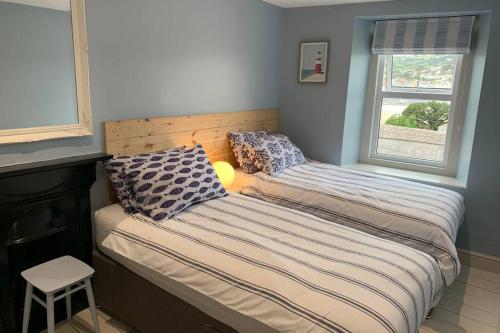 two twin beds in a room with a window at North View cottage. Shaldon village. in Shaldon