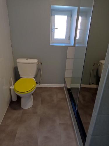 a bathroom with a toilet with a yellow lid at Git'a'Gnac in Retournac