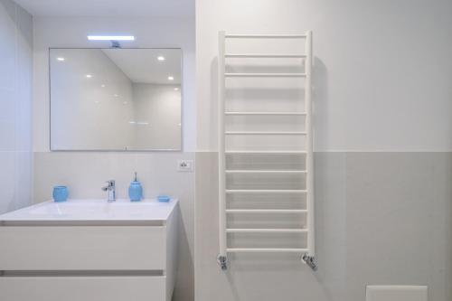 uma casa de banho branca com um lavatório e um espelho em Casa Capri Me em Capri