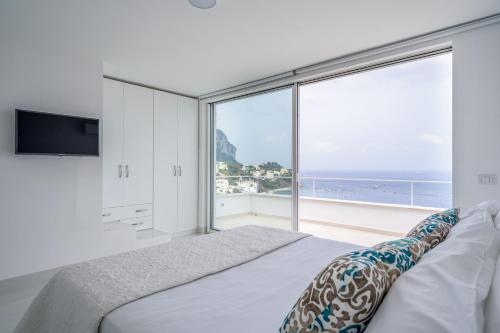 1 dormitorio con cama y ventana grande en Casa Capri Me en Capri