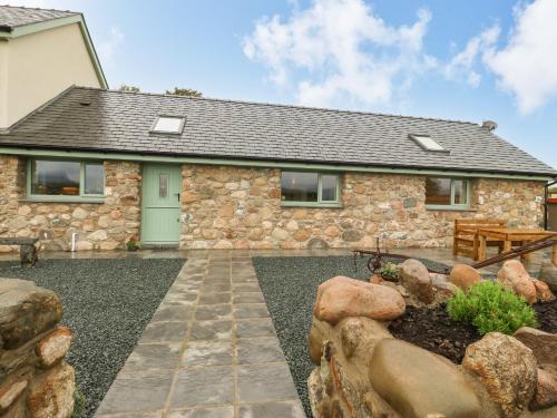 a stone house with a bench and a table at Y Felin The Granary in Caernarfon