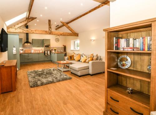 a living room with a couch and a kitchen at Y Felin The Granary in Caernarfon