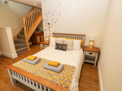 a bedroom with a bed with two pillows at Ty Gwair The Hayloft in Caernarfon