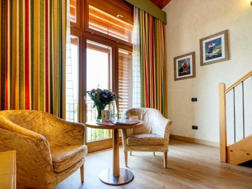 a living room with a table and chairs and a window at Active Hotel Paradiso in Peschiera del Garda