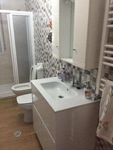 a bathroom with a white sink and a toilet at Casa Campanita in Ribadeo