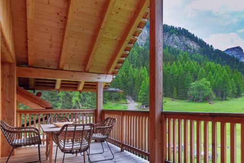 a porch with a table and chairs and a view at Chalet Mornà in San Martino in Badia
