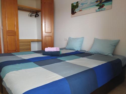 uma cama grande com azul e branco num quarto em Casa de Fabian Appartment + WIFI near beach/port em La Manga del Mar Menor