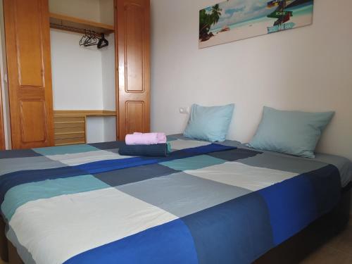 a large bed with blue and white in a room at Casa de Fabian Appartment + WIFI near beach/port in La Manga del Mar Menor