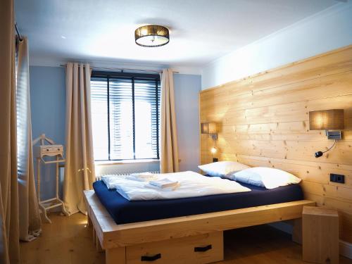 a bedroom with a bed with a wooden wall at Design Hotel ALPENLIEBE - - - - Boutique-Flair - - - - in Inzell