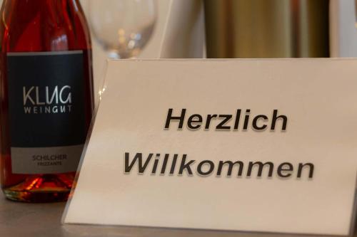 a bottle of wine and a sign with the words heritability willuminati at Ferienhaus Schilcherland in Hochneuberg