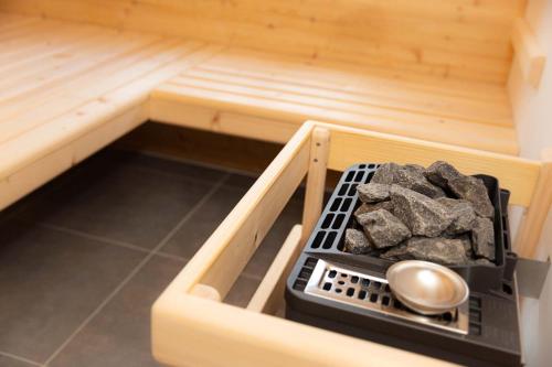a wooden sauna with a tray of rocks in it at Ferienhaus Schilcherland in Hochneuberg