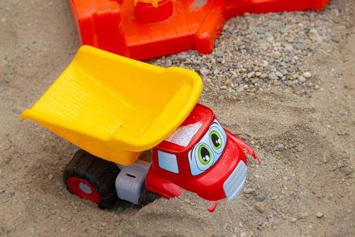 a toy truck and a toy car in the sand at Ferienhaus Schilcherland in Hochneuberg