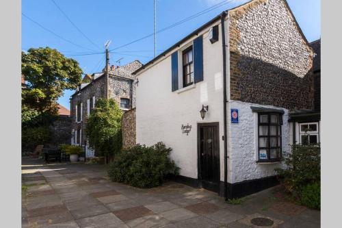 a white building with a black door on a street at Barnaby's Lodge in Broadstairs - Exclusive unmissable deals! Book now before it's too late! in Broadstairs